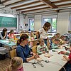 Kinder und Eltern beim gestalten von Schneidebrettern