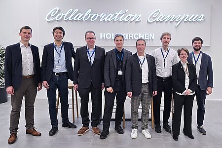 Organisatoren und Expertise stehen für ein Gruppenbild vor dem Schriftzug "Collaboration Campus" Holzkirchen.