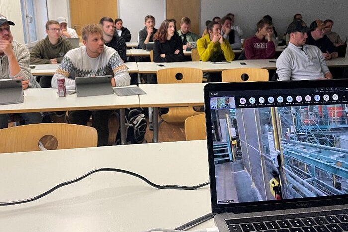 Das Bild zeigt Studierende in einem Seminarraum, die an einer digitalen Exkursion teilnehmen.