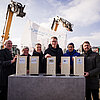 Das Bild zeigt eine Gruppe von Personen auf der Baustelle für den neuen Campus Chiemgau.