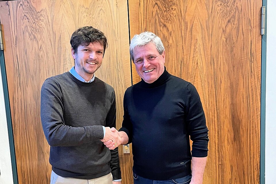 Auf dem Bild gratuliert Hochschulpräsident Prof. Heinrich Köster (rechts) Fabian Schöpfer (links) zur Ernennung zum ersten Nachwuchsprofessor der TH Rosenheim.