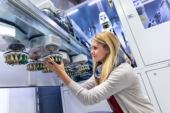Studentin der Mechatronik im Labor an einer Maschine