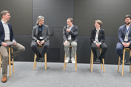 Die Diskussionsteilnehmer/-in sitzen auf Hochstühlen. Moderator Dr. Uli Kreutzer diskutierte gemeinsam mit Dr. Stefan Held, Prof. Dr. Reiner Hüttl, PD Dr. rer. Nat. habil Corinna Schmitt und Alexander Harlass (v. l. n. r.) zum Thema Cybersicherheit in Unternehmen.